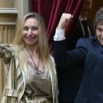 Javier Milei ao lado de Karina Milei diante de cortina vermelha